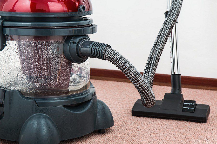 New York City carpet cleaning being performed in a commercial building with a carpet steam cleaning vacuum. NYC commercial carpet cleaning services are offered by SanMar.