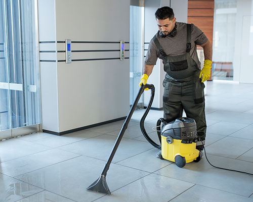 NYC commercial janitor cleaning floors in office building. SanMar cleaning services.